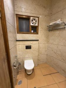 a small bathroom with a toilet and a television at Hotel Silver Bricks in Amritsar