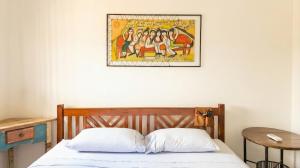 a bedroom with a bed with a picture on the wall at Apartamento do Paulão in Ubatuba +27 photos