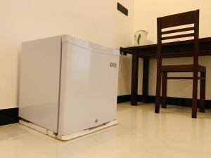 a refrigerator sitting on the floor next to a chair at water lily heaven in Tangalle