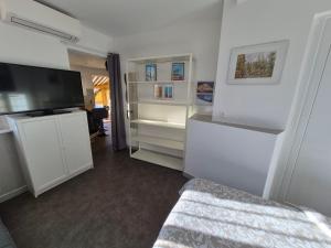 a bedroom with white cabinets and a flat screen tv at Soleillas in Vence