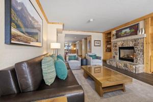 a living room with a leather couch and a fireplace at The Steamboat Grand in Steamboat Springs