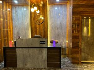 a reception desk in a lobby with a purple vase at Swarnpalace Hotel and Resort in Chaupāran