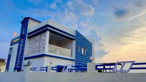 a blue and white building with chairs in front of it at Swarnpalace Hotel and Resort in Chaupāran