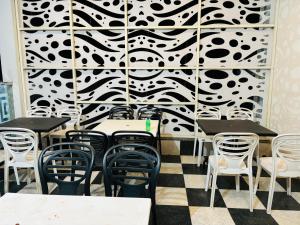 a restaurant with tables and chairs and a black and white wall at Swarnpalace Hotel and Resort in Chaupāran