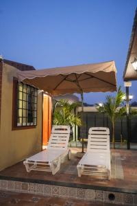 two lounge chairs and an umbrella on a patio at Manish Inn Resort in Daulatābād