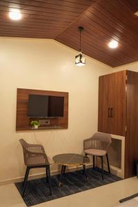 a waiting room with two chairs and a table and a tv at Manish Inn Resort in Daulatābād