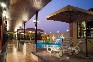 a couple of chairs and an umbrella next to a swimming pool at Manish Inn Resort in Daulatābād