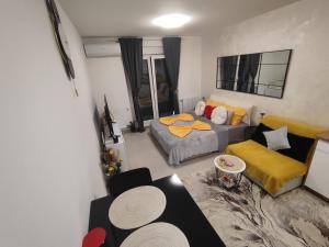 a living room with a bed and a couch at Apartman BULEVAR1 sa garažom in Doboj