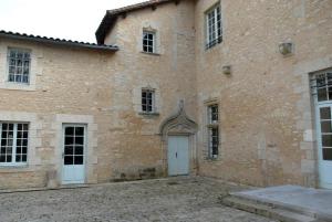 a large brick building with a white door at Château d'ayron in Ayron