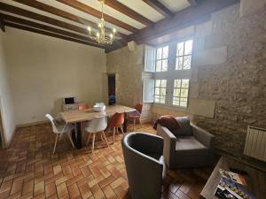 a living room with a wooden table and chairs at Château d'ayron in Ayron