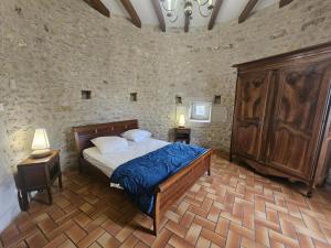a bedroom with a bed in a stone wall at Château d'ayron in Ayron