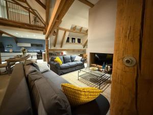 a large living room with a couch and a tv at A l'Ancienne Ferme in Steinseltz