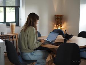 a woman sitting at a table with a laptop at 12 Casa d'Avó in Albergaria-a-Velha +41 photos