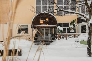a train in the snow in front of a building at Home Hotel Smedjan in Sandviken