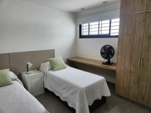 a bedroom with two twin beds and a window at Departamento macrocentro I, espacioso Río Cuarto in Río Cuarto