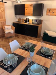 a wooden table with plates and wine glasses on it at BergOase-Apart am Feldberg in Feldberg +102 photos
