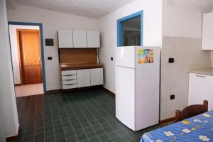 a kitchen with a white refrigerator in a room at La Mansarda Navarrese in Santa Maria Navarrese