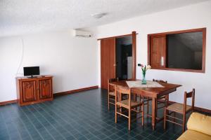 a dining room with a table and chairs and a tv at La Mansarda Navarrese in Santa Maria Navarrese +6 photos