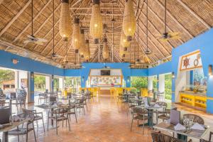ein Esszimmer mit Tischen und Stühlen und einer Bühne in der Unterkunft Royal Decameron Salinitas - All Inclusive in Los Cóbanos