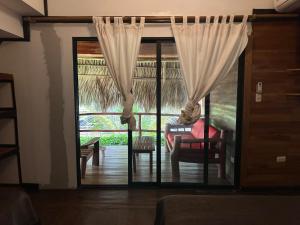 a living room with a sliding glass door with a chair at Hotel Bahía in Marisco Guapinol