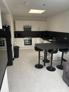 a kitchen with a black table and two stools at Beach View Guesthouse in Peterhead
