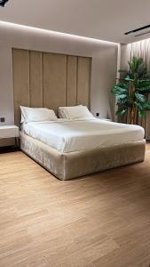 a large bed in a bedroom with a wooden floor at Villa 22 in Ajman  +23 photos