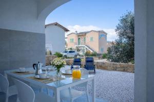 a white table with flowers and orange juice on it at Residenza Sa Olia in Budoni