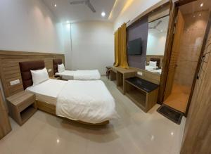 a bedroom with two beds and a sink and a mirror at Hotel Silver Bricks in Amritsar +9 photos