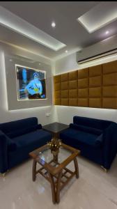 a living room with blue couches and a tv at Hotel Silver Bricks in Amritsar