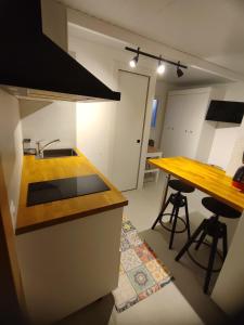 a kitchen with a sink and a counter with two bar stools at Apartamento in Arona