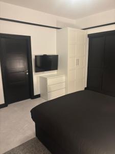 a bedroom with a bed and a flat screen tv at Beach View Guesthouse in Peterhead