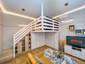 a living room with a staircase and a tv at Frida Loft in Pécs