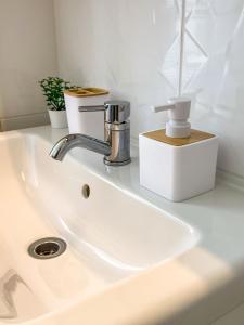 a white sink with a faucet on top of it at Frida Loft in Pécs +16 photos
