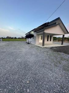 a small building with a table and an umbrella at Homestay Khan in Arau +10 photos