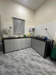 a kitchen with a sink and a counter top at Homestay Khan in Arau