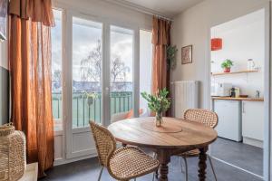 a dining room with a table and chairs and a window at La Cabane Parking privatif et Balcon in La Riche