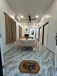 a living room with a table and a dining room at Homestay Khan in Arau