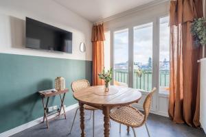 a dining room with a table and chairs and a window at La Cabane Parking privatif et Balcon in La Riche