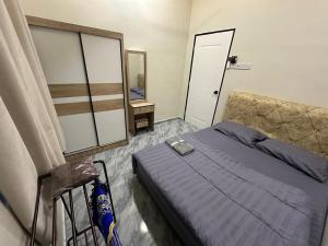 a bedroom with a blue bed and a mirror at Homestay Khan in Arau