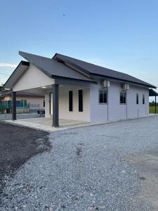 a white building with a black roof at Homestay Khan in Arau