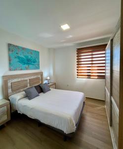 a bedroom with a bed with two pillows and a window at Edificio Type I in Puente Genil