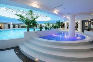 a large swimming pool with a spa with stairs and a swimming pool at Apartament Hanza Tower 218 in Szczecin