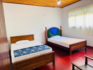 a bedroom with two beds and a window at Nihal Villa in Weligama