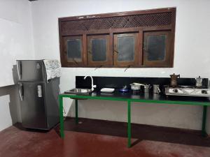 a kitchen with a green table and a refrigerator at Nihal Villa in Weligama
