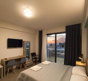 a hotel room with a bed and a desk and a window at Elegant Dream Suites in Agia Anna +99 photos