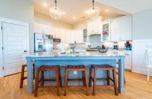 a kitchen with a large blue island with stools at Sea Fever - Duck, Saltaire, 130 Yds to Beach, Ocean View, Pool, Hot Tub, Tiki Bar, Flex Stays in Duck