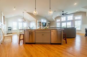 an open kitchen and dining room with a table at Sea Fever - Duck, Saltaire, 130 Yds to Beach, Ocean View, Pool, Hot Tub, Tiki Bar, Flex Stays in Duck