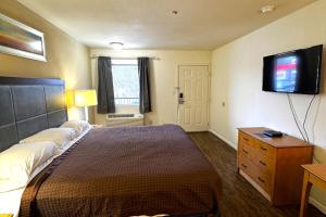 a bedroom with a bed and a flat screen tv at Woodbridge Inn By OYO Rome in Rome +23 photos