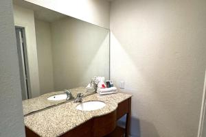 a bathroom with two sinks and a large mirror at Woodbridge Inn By OYO Rome in Rome