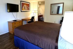 a small hotel room with a bed and a desk at Woodbridge Inn By OYO Rome in Rome